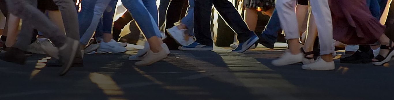 Gradska šetnica koja prikazuje desetke ljudi koji hodaju u suprotnim smjerovima dok prelaze ulicu