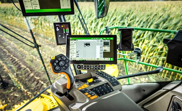 Samohodni silažni kombajn F9 700 koji utovaruje Joskinovu prikolicu koju vuče traktor John Deere 6R