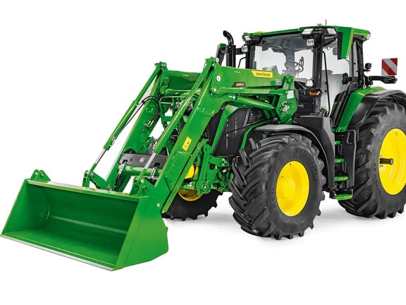Traktor John Deere s podignutim prednjim utovarivačem i žlicom, studijska fotografija koja ističe doseg i visinu podizanja utovarivača.