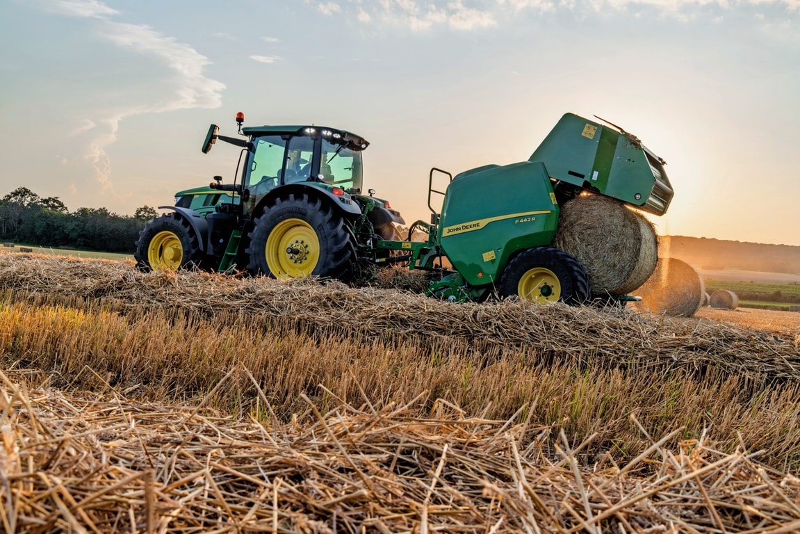 John Deere F442M balirka koju vuče traktor John Deere 6M koji izbacuje balu sijena