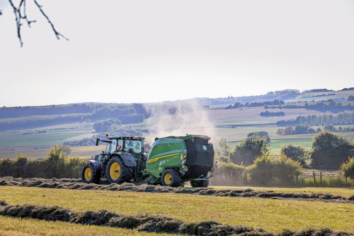John Deere V462R kojeg vuče traktor John Deere 6R 185 za baliranje sijena