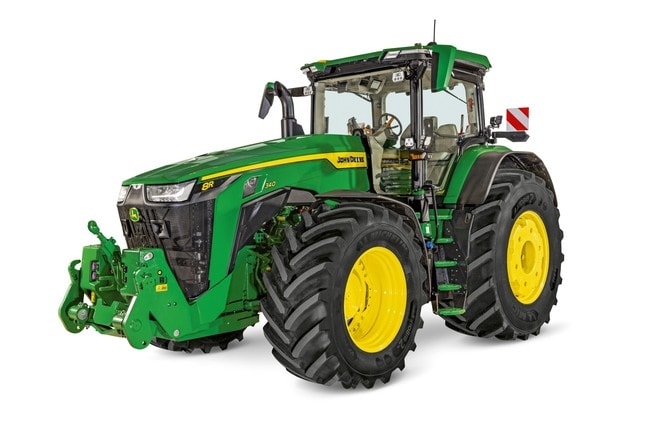 Traktor s kotačima John Deere 8R 340 sa zatvorenom kabinom, velikim poljoprivrednim gumama i prednjim prihvatom prikazan na bijeloj studijskoj pozadini.
